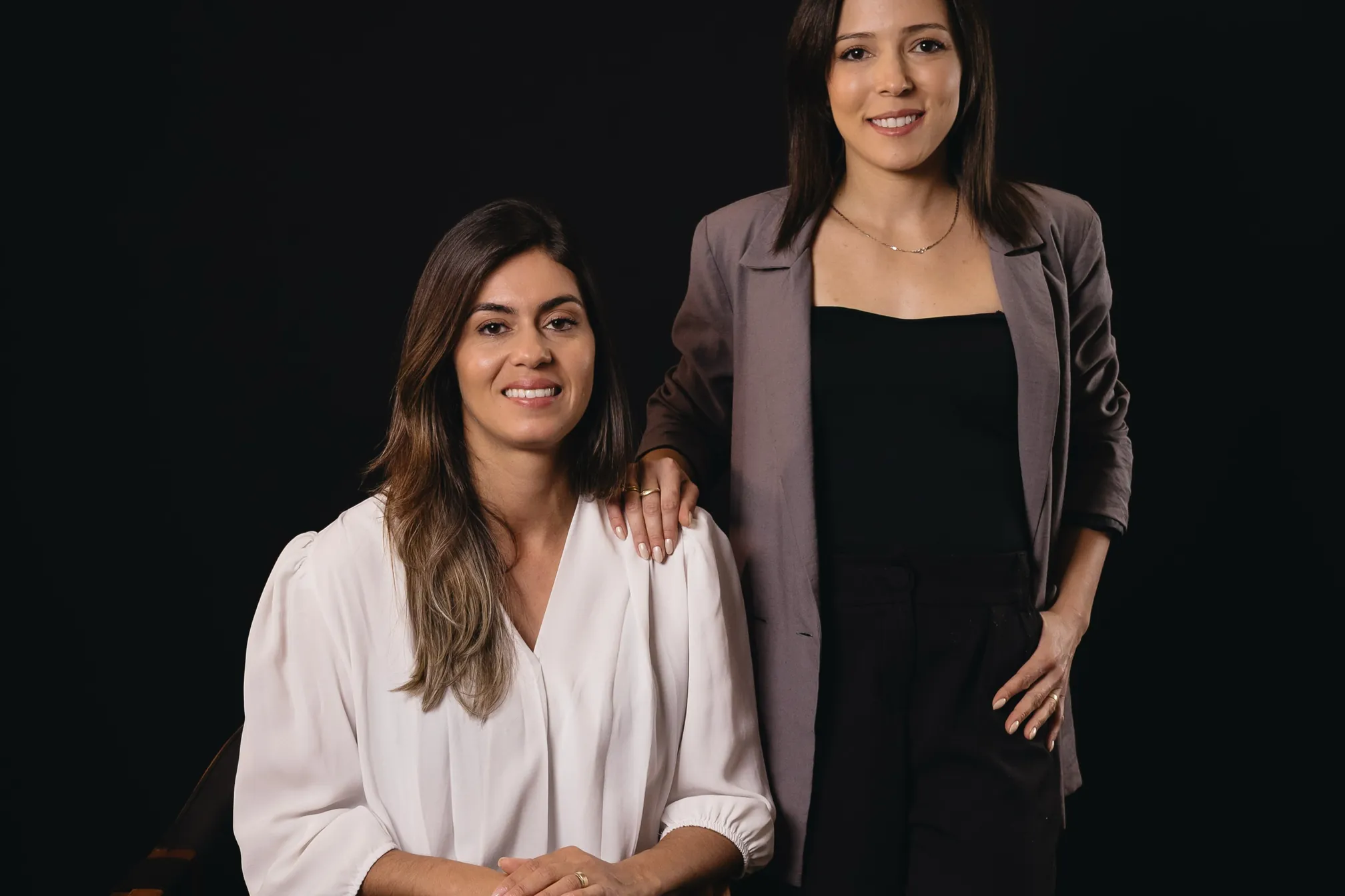 Sílvia Lopes e Alexa Costa, sócias da Casa Modelo, em retrato sobre fundo escuro